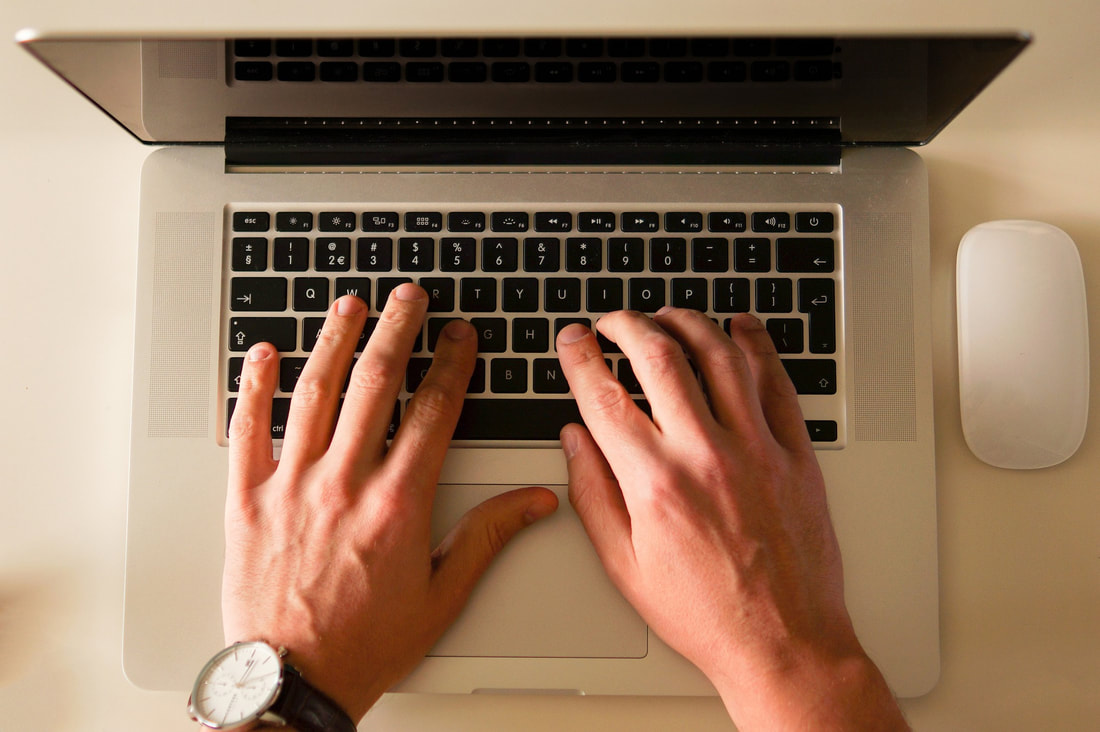 Hands typing on Macbook